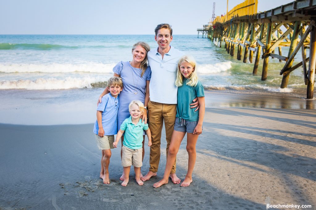 A beautiful family of 5 posing on the beach in Myrtle Beach, SC for myrtle beach photographer beachmonkey photography.